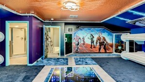 A room with a unique ceiling design, a large mural, and a reflective floor. - The Marvel Mansion 5BR Pool Home Near Disney World (Four Corners)