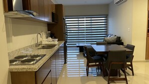 Une cuisine moderne dotée d’un îlot central, d’appareils électroménagers intégrés et d’un coin repas avec une table et des chaises.