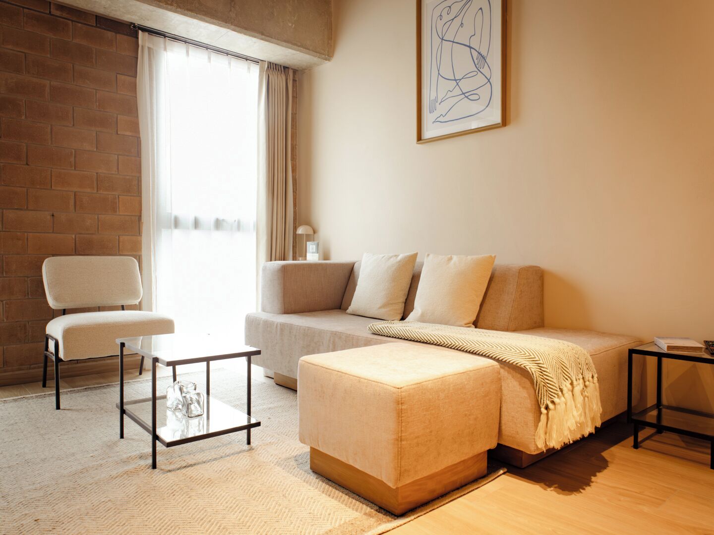Een moderne woonkamer met een bank, poef, fauteuil en salontafel.