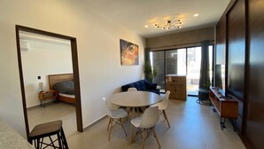 Un salon moderne avec une table à manger ronde, un canapé et une grande fenêtre.