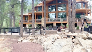 Experience the serene natural surroundings from the comfort of your balcony, overlooking the property's patio area with a hot tub.