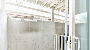 A concrete wall with a metal gate and a glass door. - The Hygge apt C (Colorado Springs)