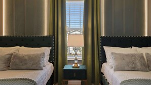 A hotel room with two beds, a nightstand, and a window with curtains. - Grand Marvel & Star Wars Villa | Windsor Island (Davenport)