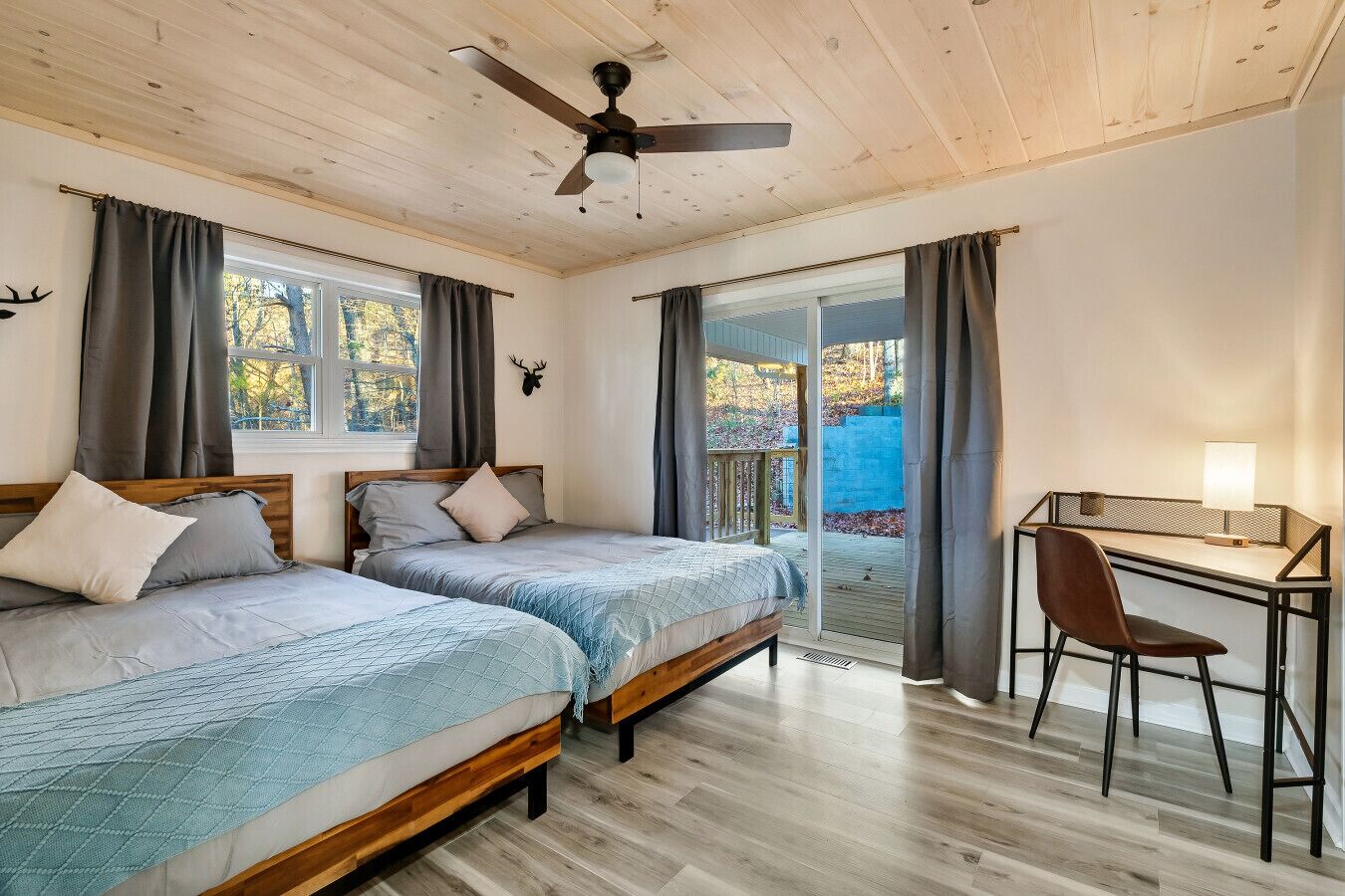 Un dormitorio con dos camas, un escritorio y una silla.