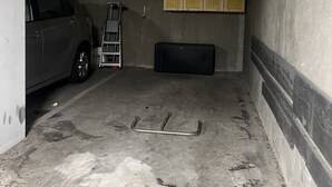 A parking garage with a car, a ladder, and a wooden cabinet. - Appartement T2 avec terrasse et parking couvert à proximité de la plage (LE CAP D AGDE)