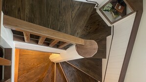Un escalier en colimaçon avec des marches en bois et une rampe blanche.