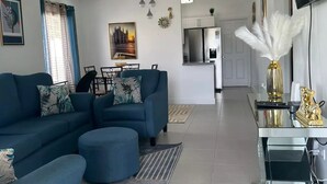 Un saló modern amb un sofà modular, una zona de menjador i una cuina.