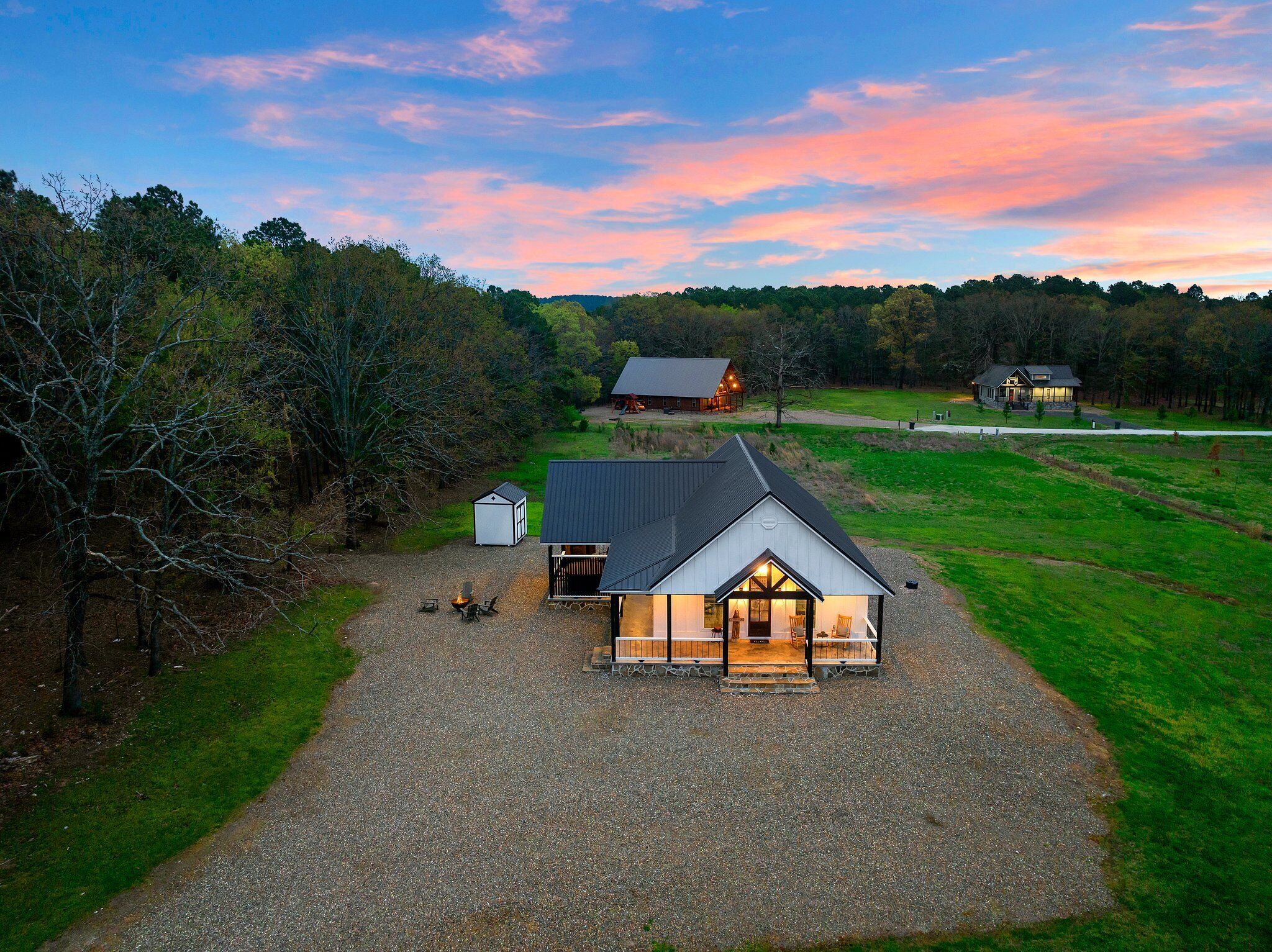 A large, single-story house with a gravel driveway and a small shed nearby.