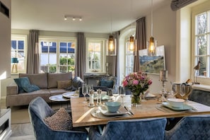 A dining area with a wooden table set for four, surrounded by blue upholstered chairs.
