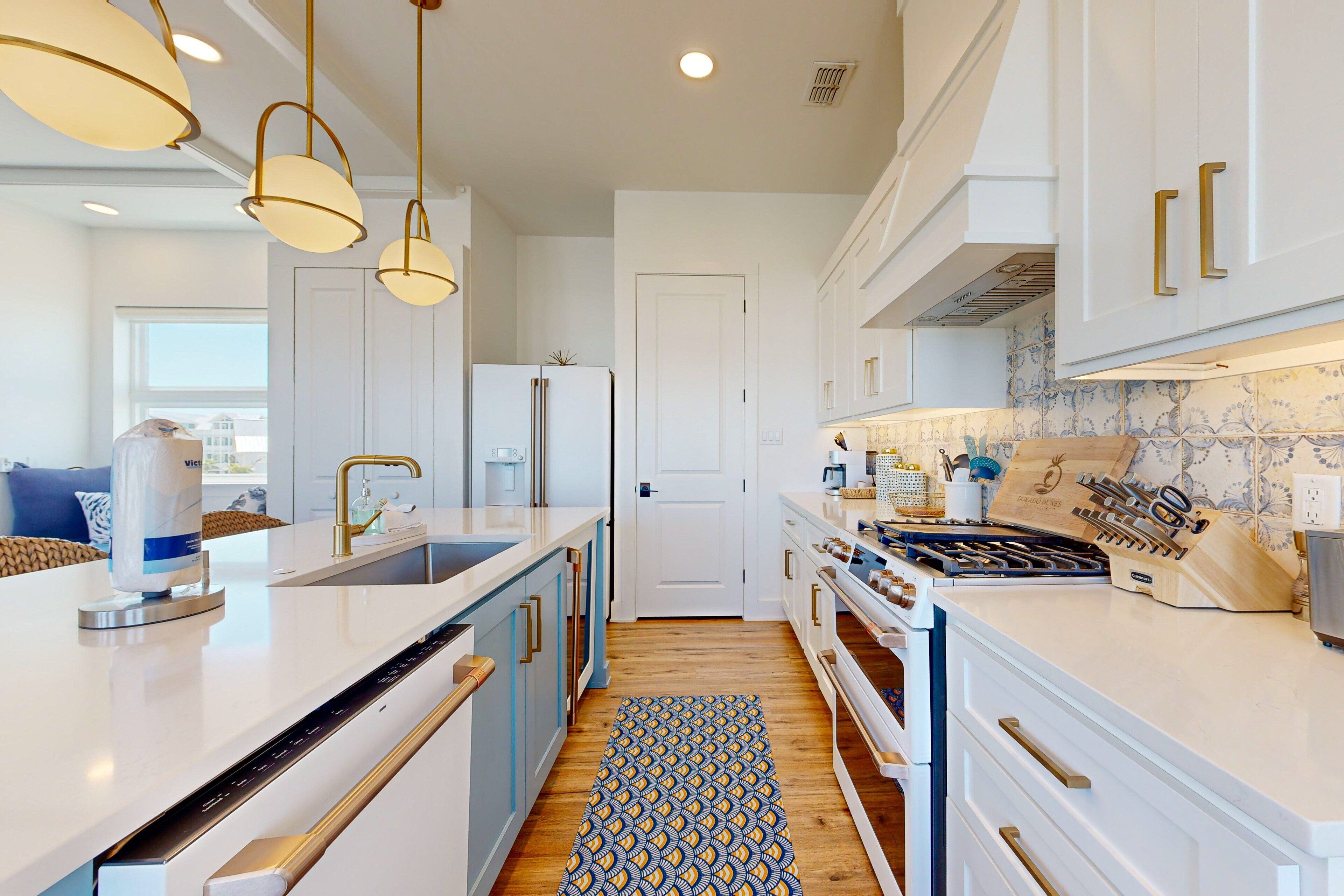 A modern kitchen with white cabinetry, a built-in oven, a gas stove, and pendant lighting.