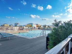 A pool area with lounge chairs and a wooden deck.
