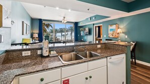 A modern kitchen with granite countertops, stainless steel sink, and white cabinets. - Shores Of Panama 314 - 1 Bd+bunks, Sleeps 6. Same Level Parking, Free Fun! 1 Bedroom Condo by RedAwning (Panama City Beach)