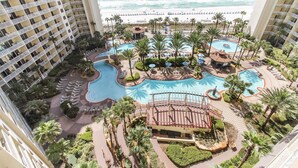 Un complexe hôtelier doté de plusieurs piscines, de palmiers et offrant une vue sur la plage.
