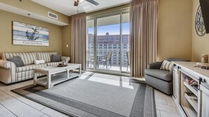 A modern living room with a sofa, armchairs, a coffee table, and a large window with curtains. - Shores of Panama 1804 - 2 Bedroom + Bunkroom . Updated! Free Fun. 2 Condo by RedAwning (Panama City Beach)