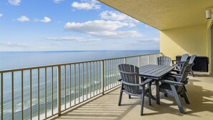 A balcony with a view of the ocean, a table, and chairs. - Gulf Crest 2005 - 2 Bedroom W/Fantastic View! Family Friendly! Sleeps 8 Condo by RedAwning (Panama City Beach)