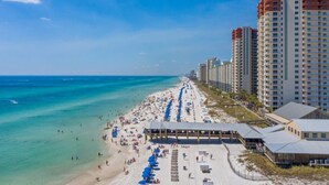 A beachside hotel with a long sandy beach, ocean view, and high-rise buildings in the background. - Shores Of Panama 1426 1 Bd+bunk Room, Sleeps 6. Renovated! Sunset View! Free Fun! 1 Bedroom Condo by RedAwning (Panama City Beach)