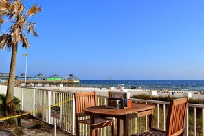 Relax in a beachside seating area with a wooden fence separating it from the shore.