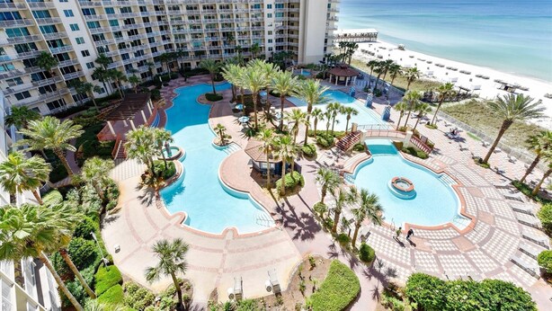 A resort with multiple swimming pools, palm trees, and a beach view. - Shores of Panama 808- 1 Bedroom+Bunk Room, Free Fun! Updated! Sleeps 6. 1 Condo by RedAwning (Panama City Beach)