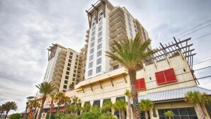 A multi-story hotel with balconies, palm trees, and a clear sky. - Origin 1038, Sunset & Gulf View! Perfect For 2! Free Fun! 1 Bedroom Condo by RedAwning (Panama City Beach)