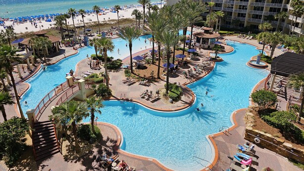 A resort with a large pool area, a beach, and a high-rise building. - Shores Of Panama 621-sleeps 8, Free Beach Fun! Reserved Parking Space! 2 Bedroom Condo by RedAwning (Panama City Beach)