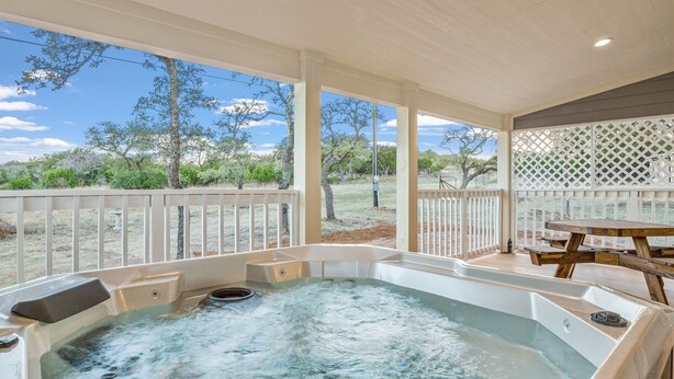 A hot tub with a view of a dry landscape and trees. - Appian Way Maltese Cottage 1 Bedroom Cabin by RedAwning (Fredericksburg)