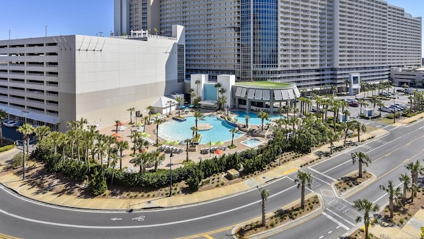 A large hotel with multiple floors, a swimming pool, and a parking area. - Laketown Wharf 1003, Gulf View, Sleeps 6. Free Fun! Updated! 1 Bedroom Condo by RedAwning (Panama City Beach)