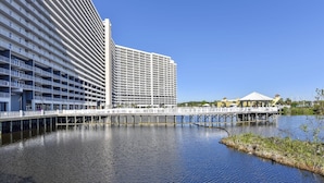 A waterfront hotel with multiple floors, a pier extending over the water, and a clear blue sky. - Laketown Wharf 1003, Gulf View, Sleeps 6. Free Fun! Updated! 1 Bedroom Condo by RedAwning (Panama City Beach)