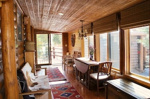 A rustic wooden interior with a dining area, wooden benches, and large windows. - Cozy chalet on the Swan River at Tiger Run (Breckenridge)