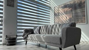 A modern living room with a grey sofa, a black woven basket, and a painting on the wall. - House close to the beach, adventure parks and authentic Puerto Rican restaurants (Luquillo)
