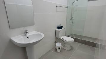 Casa de banho com lavatório suspenso, sanita e chuveiro.