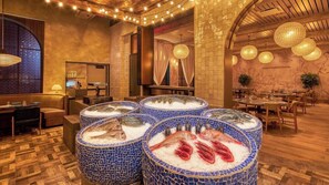 A restaurant interior with round tables, chairs, and a fish display.