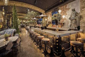 A bar area with a long counter, stools, and decorative lighting. - 1-Bedroom Suite at a 4⭐️ Hotel (Las Vegas)