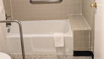 A bathroom with a bathtub, a shower area, and a toilet.