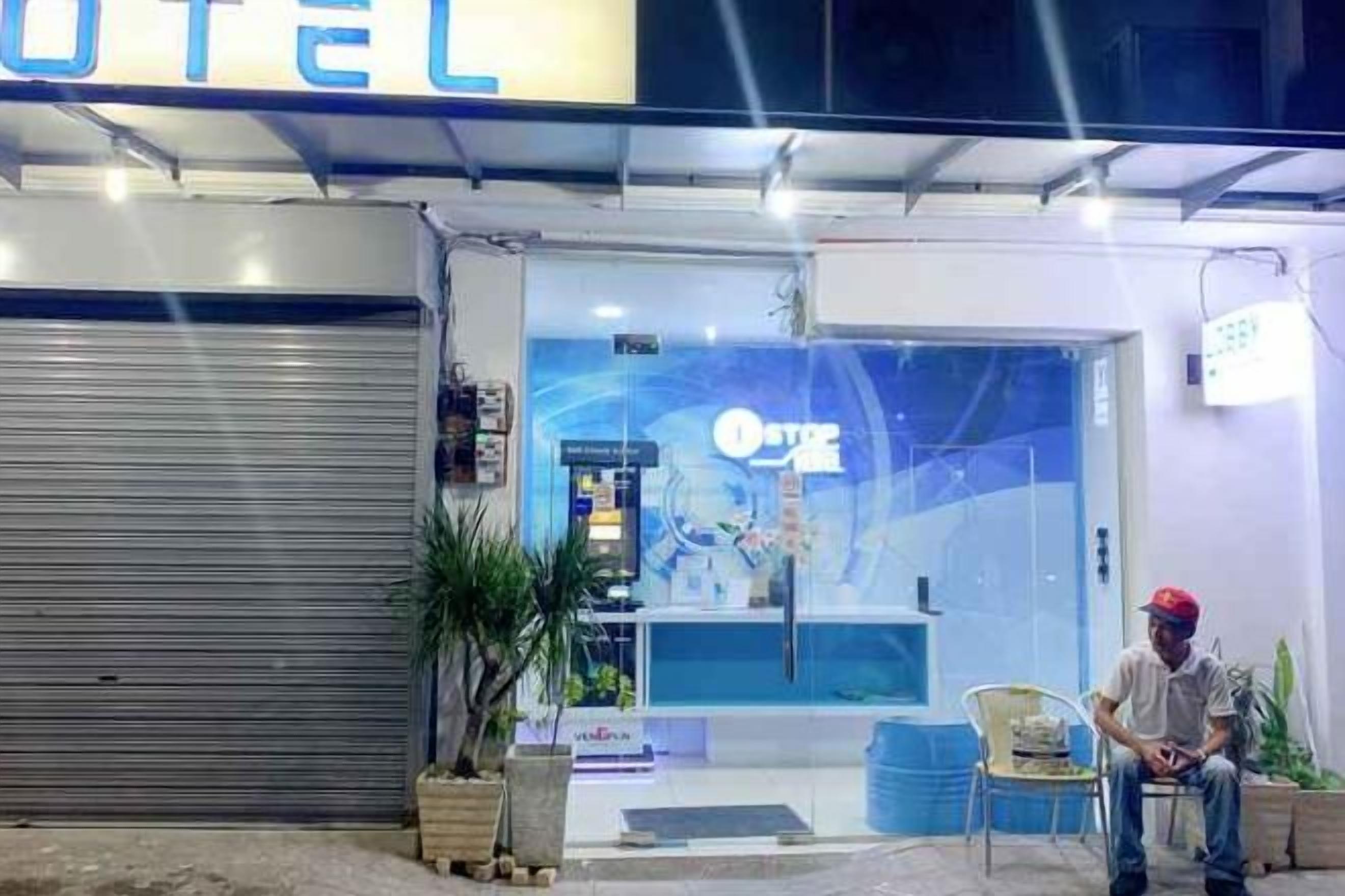 Ein Hotel Eingang mit heruntergelassenem Rollo, einer Rezeption und einem Stuhl davor.