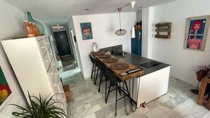 A modern kitchen with a central island, bar stools, and a dining area. - The funny Tuna in Zahara de los Atunes (Zahara de los Atunes)
