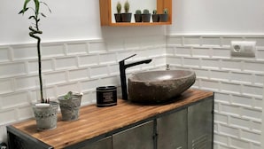 A bathroom with a wooden vanity, a stone sink, and a mirror above. - The funny Tuna in Zahara de los Atunes (Zahara de los Atunes)
