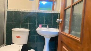 A bathroom with a toilet, sink, and mirror. - D Ruiz Hotel (Quevedo)