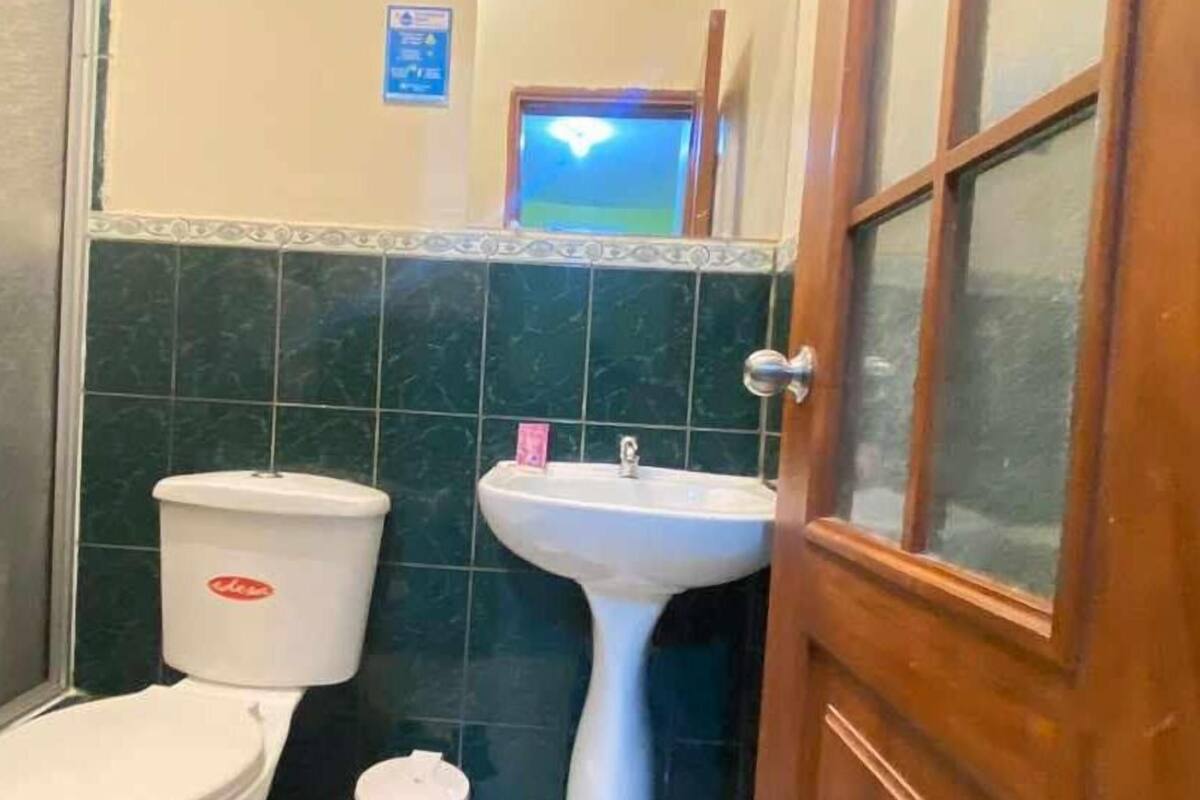 A bathroom with a toilet, sink, and mirror.