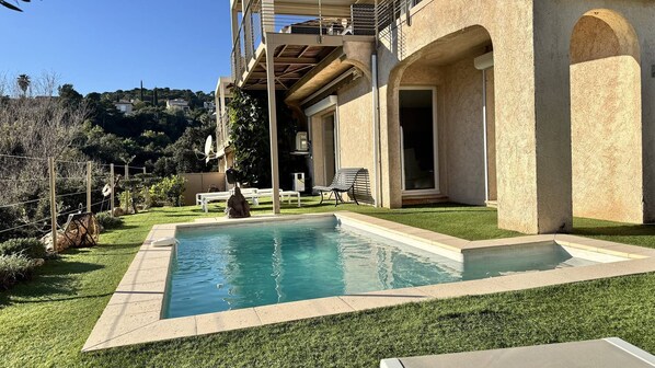 Una piscina con vistas despejadas del entorno, incluyendo un edificio con balcón y una estatua.
