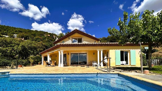 Una casa de dos pisos con piscina delantera.