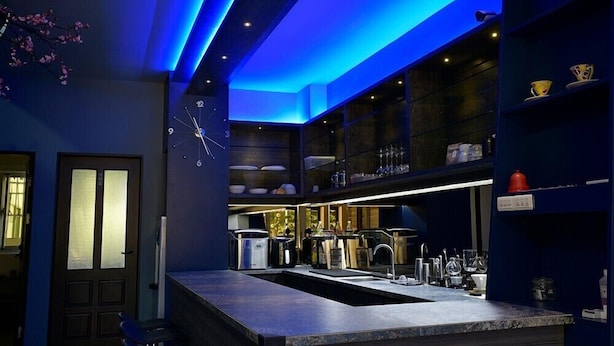A modern kitchen with a central island, built-in shelves, and a clock on the wall. - LONG LIFE B&B (Taitung)
