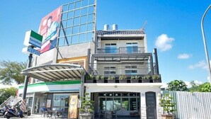 A two-story building with a FamilyMart store on the ground floor, a covered entrance, and a balcony with potted plants. - LONG LIFE B&B (Taitung)