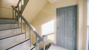 A staircase with a handrail leading to a door. - Paradise Found 4BR Villa,Fits 22 PAX, 6-Min to Lee Garden (Hat Yai)