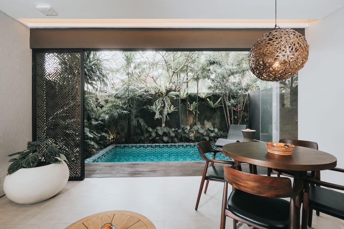 A modern dining area with a round table, chairs, and a decorative hanging light fixture.