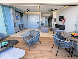 A modern interior with a dining area, sofas, and a kitchen in the background.