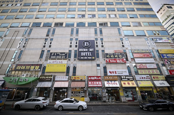A hotel with multiple floors and various shops on the ground level.