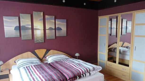 Une chambre à coucher avec un lit, une table de chevet, une lampe et une armoire.