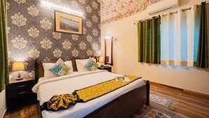 Ein Hotelzimmer mit Bett, Nachttischen, einem Spiegel, einem Bilderrahmen und Vorhängen.