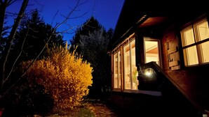Ein Haus mit einer sichtbaren Veranda und einem Fenster mit Blick ins Innere.