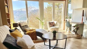 Ein modernes Wohnzimmer mit einer Couch, einem Sessel und einem runden Couchtisch.